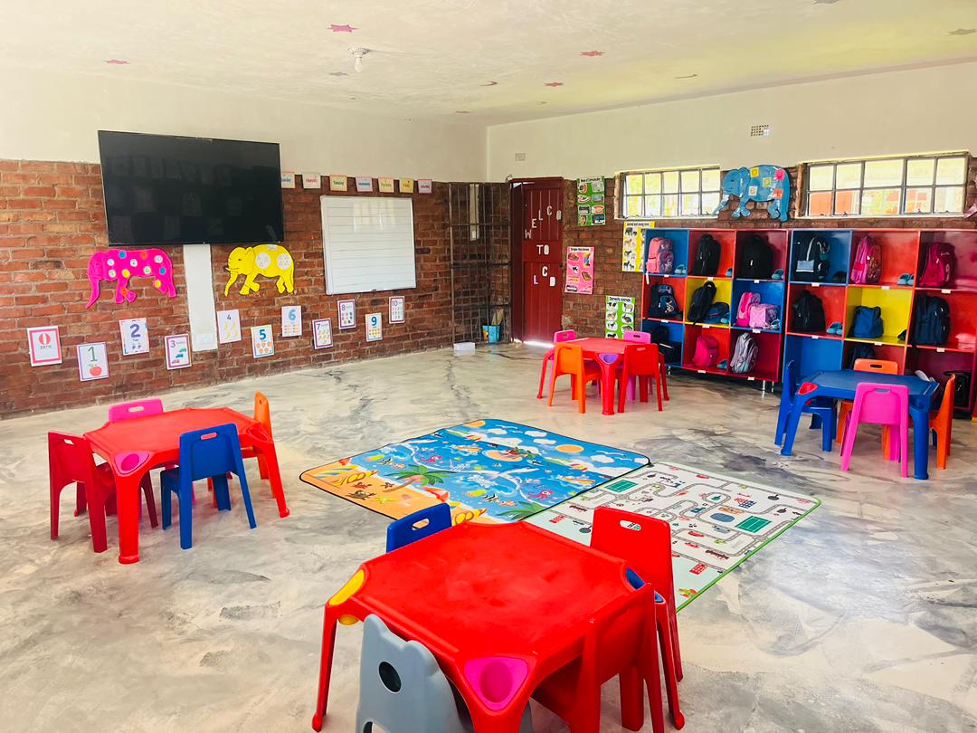 Bright early-years classroom with colourful tables and learning aids